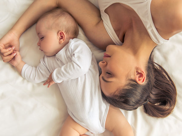 woman laying in bed with her baby